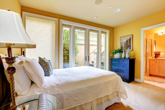 yellow master bedroom with bathroom entrance