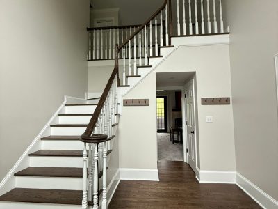 home stairwell with white walls and stained wood steps