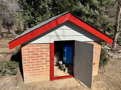 well house with red painted trim