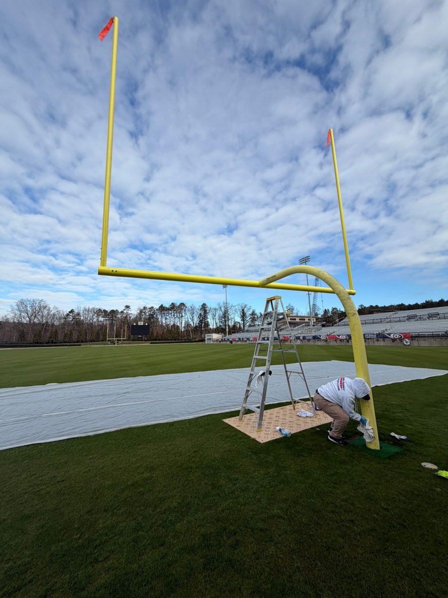 painter working on yellow football goalpost Preview Image 7