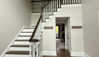 home stairwell with white walls and stained wood steps
