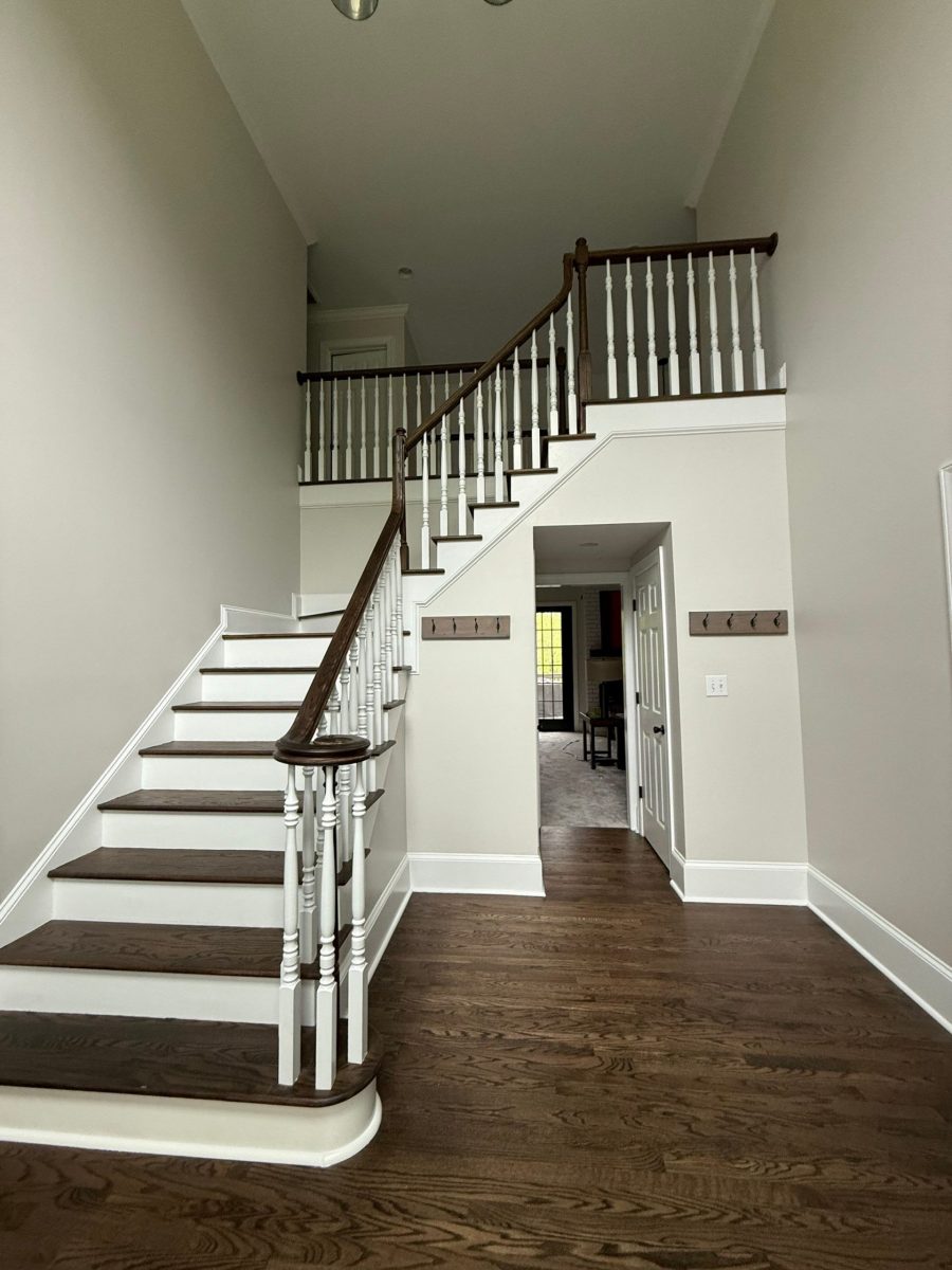 home stairwell with white walls and stained wood steps