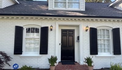 white painted brick house with black accents and trim