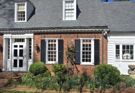brick home exterior with painted trim and shutters