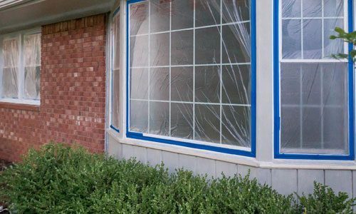 brick home during painting blue tape