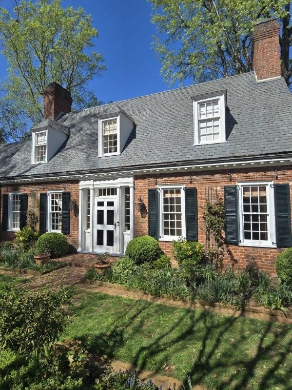 brick home exterior with painted trim and shutters
