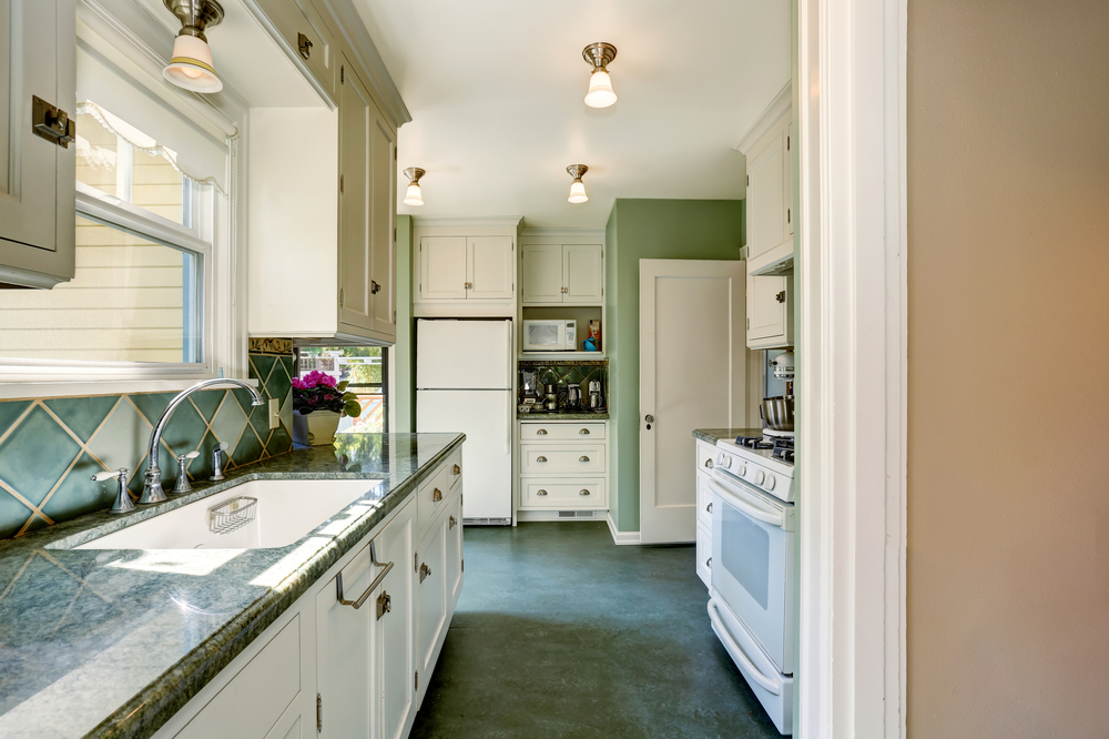 Green kitchen with white cabinets