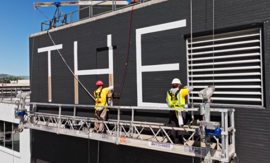 painters on scaffolding painting side of high rise building