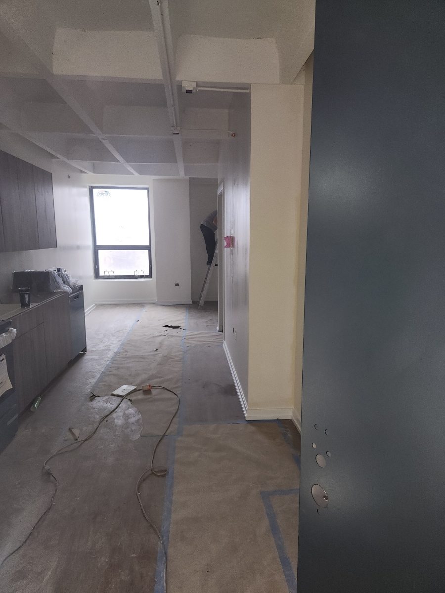 professional painter on a ladder during the painting process in an apartment room on Broadway Chicago IL Preview Image 3