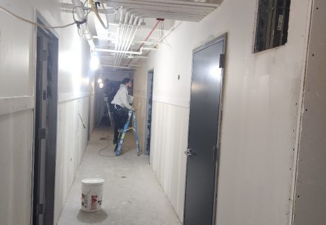 professional painter during painting process in an apartment complex hallway on Broadway Chicago