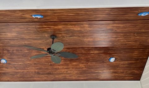 stained wood ceiling with ceiling fan