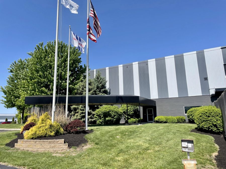 exterior of painted industrial building with flag poles in front Preview Image 8
