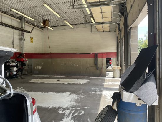dirty car bay before power washing services.
