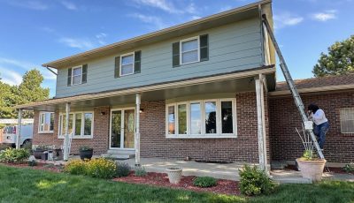 brick and siding home with painter on a ladder