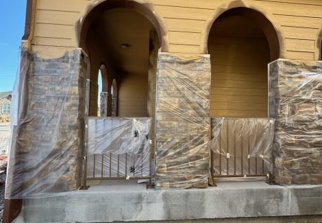 side of house with protective plastic for painting