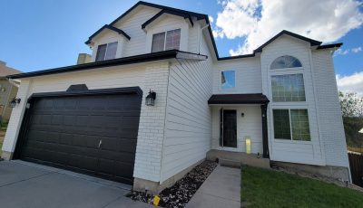 home exterior with white siding and black accents on door, garage, and trim