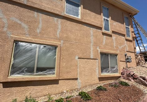rear side of stucco house with patched cracks