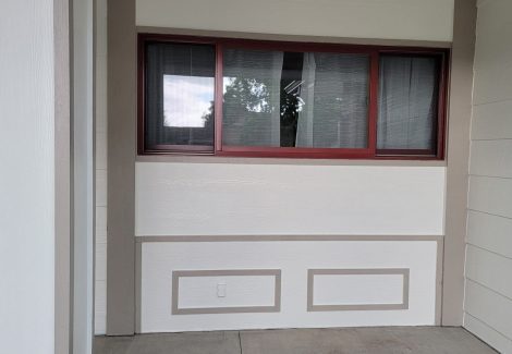 white exterior wall with red trim around window