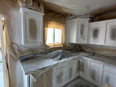 kitchen cabinets with protective coverings during painting