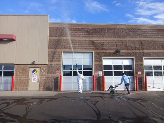 CertaPro painter power washing exterior of Costco building