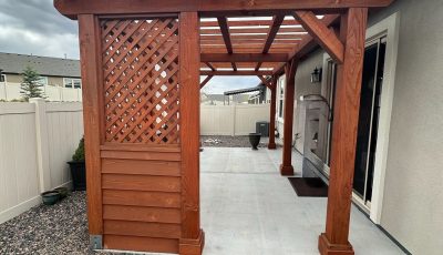 stained wooden pergola behind home