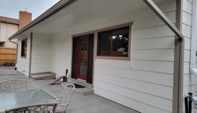 side of house with white painted siding and red trim/accents