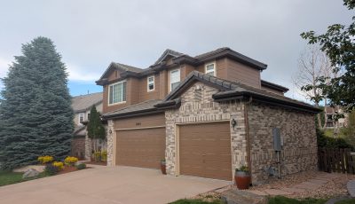 house exterior with brick and brown painted siding and garage doors