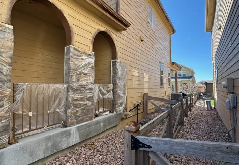 side of house with protective plastic for painting