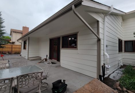 side of house with white painted siding and red trim/details