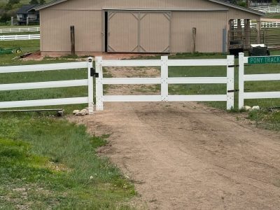 front of repainted barn and white fence