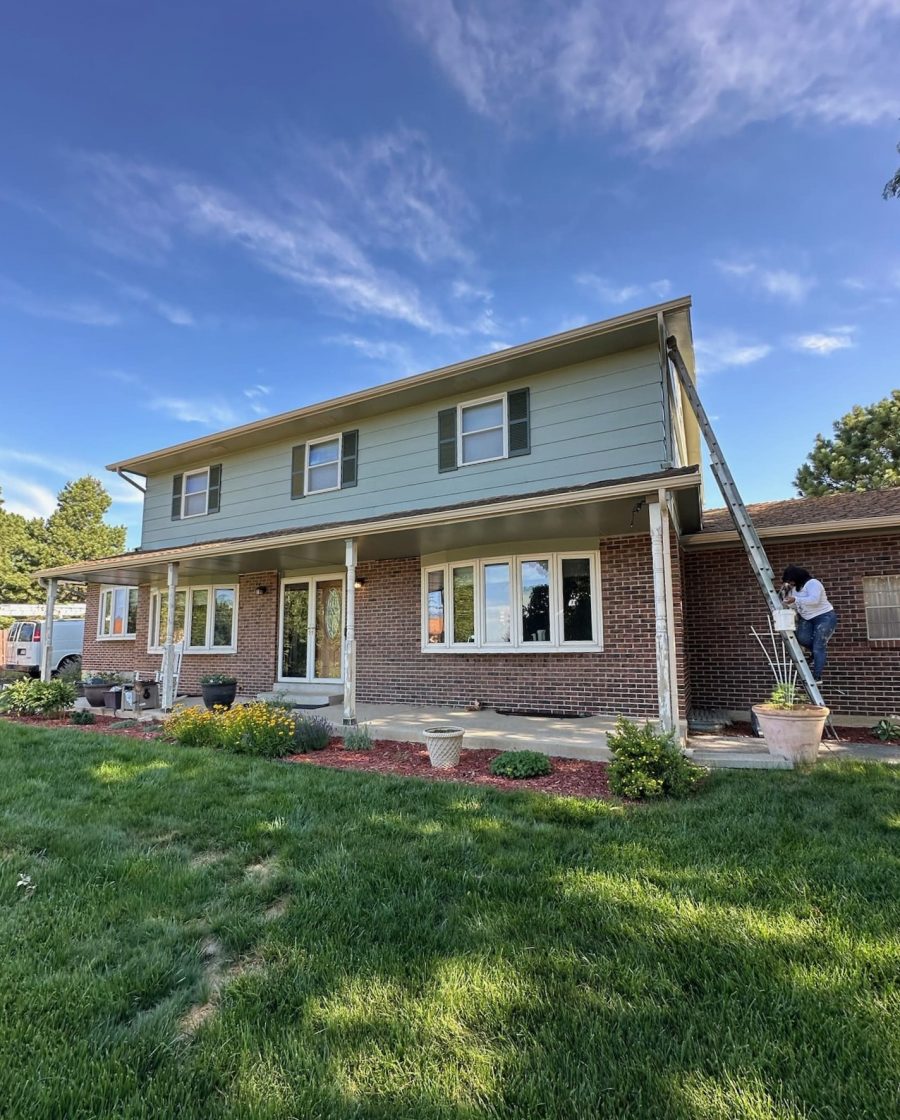 brick and siding home with painter on a ladder