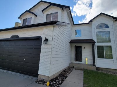home exterior with white siding and black accents on door, garage, and trim