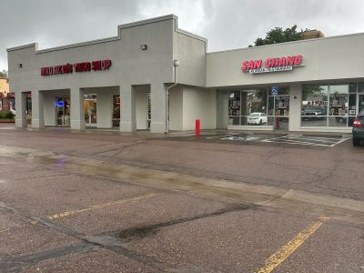 parking lot and storefronts of painted shopping center