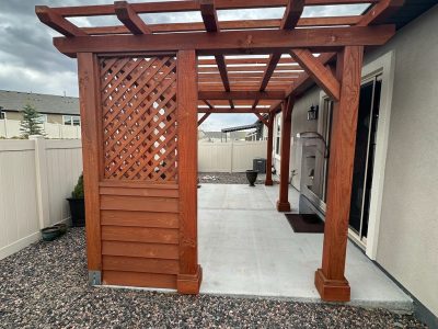 stained wooden pergola behind home