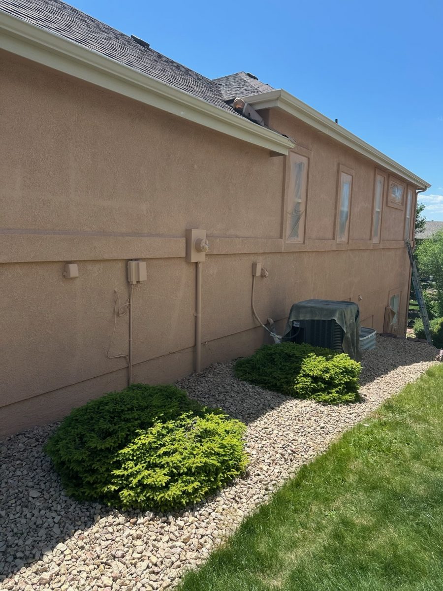 side of painted stucco house with plastic sheeting on windows Preview Image 2