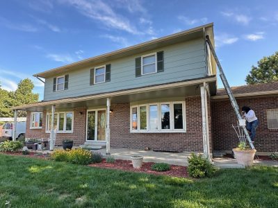 brick and siding home with painter on a ladder
