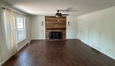 empty main room in house with hardwood floors and fireplace