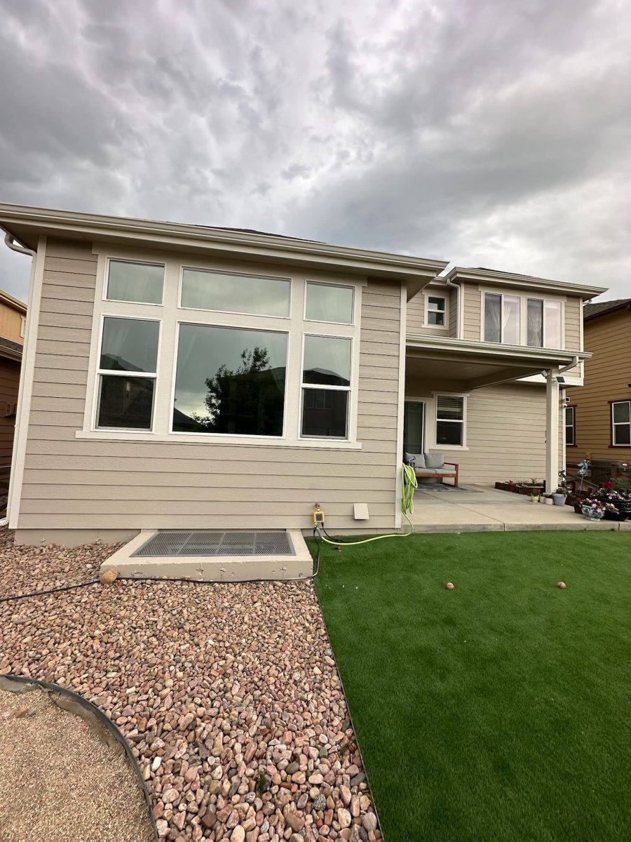 back of house with tan siding and gravel and grass ground cover Preview Image 2