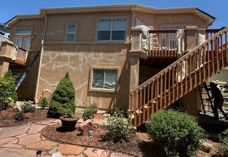 rear side of stucco house with patched cracks
