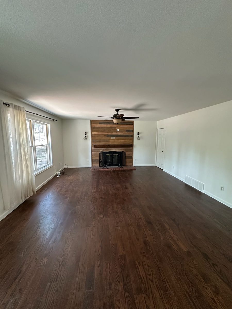 empty main room in house with hardwood floors and fireplace
