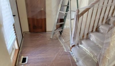 staircase and foyer covered in plastic sheeting for painting