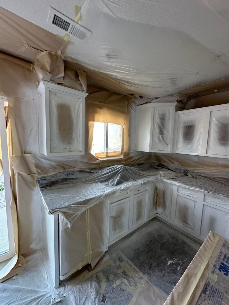 kitchen cabinets with protective coverings during painting