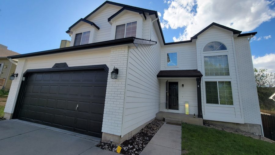 home exterior with white siding and black accents on door, garage, and trim