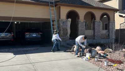 painters working around protective coverings on outside of house