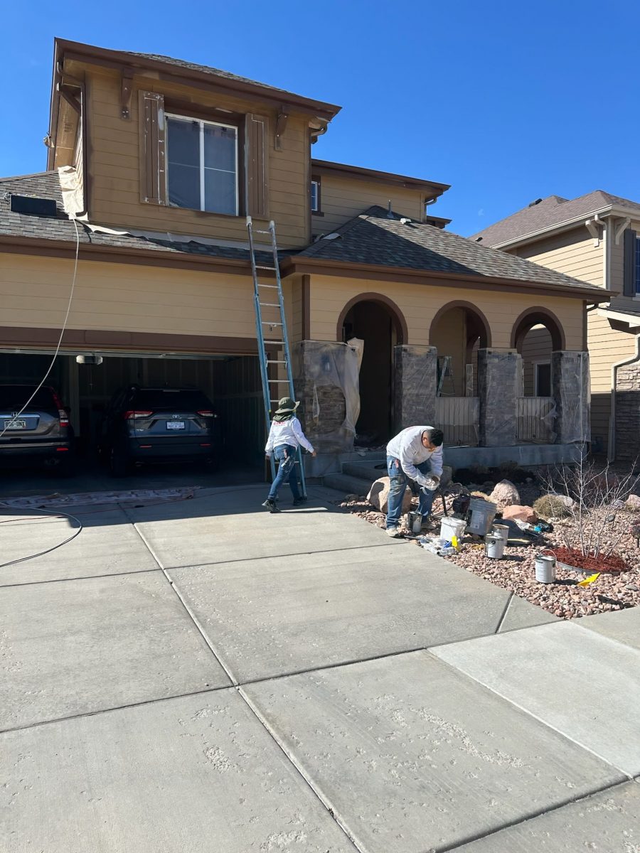 painters working around protective coverings on outside of house