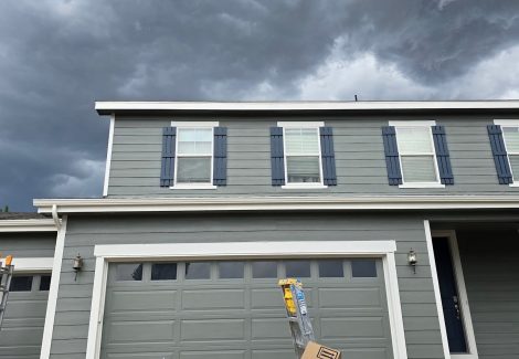 home with grey painted siding and blue shutters