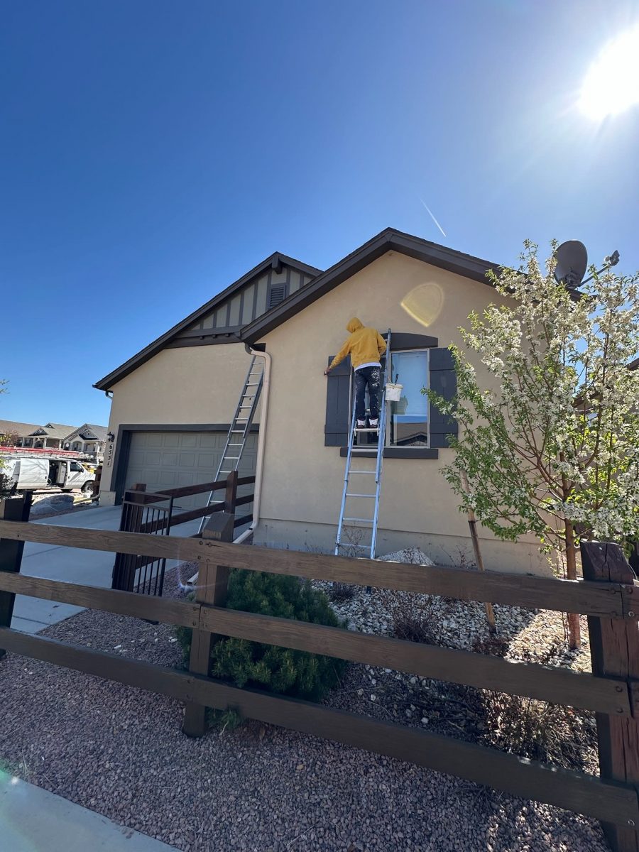painter on ladder painting a stucco house Preview Image 2