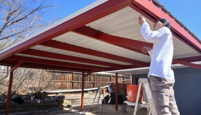 man on ladder under carport