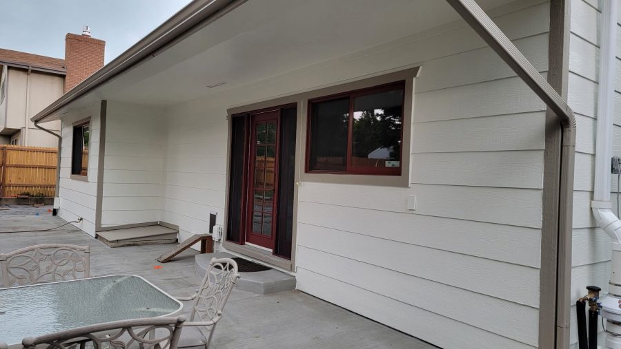 side of house with white painted siding and red trim/accents