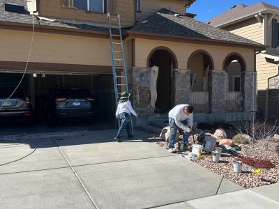 painters working around protective coverings on outside of house